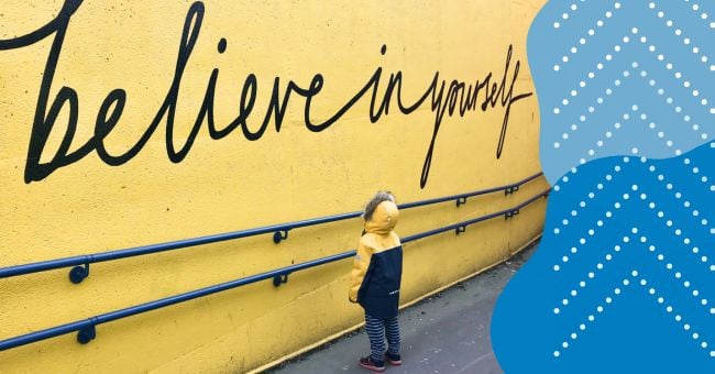 A child looks at a sign with Believe in Yourself on it