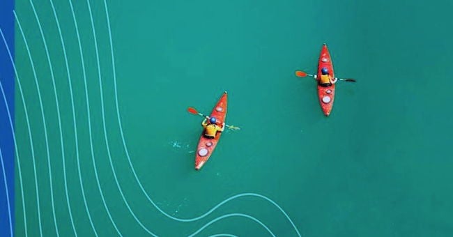 Two kayaks in a blue sea seen from above.
