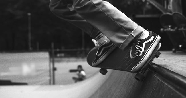 A teenager's feet on a skateboard on a ramp