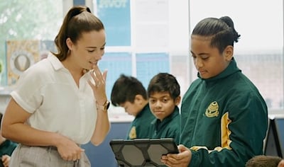 Student talking to teacher looking at tablet BECOME 