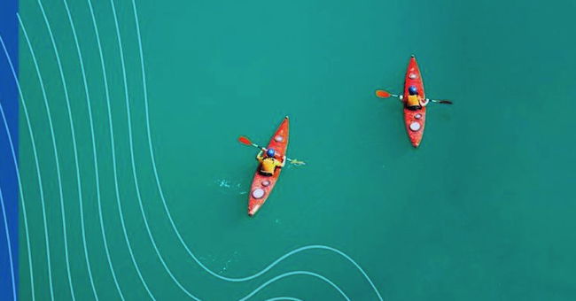 Two kayaks in a blue sea seen from above.