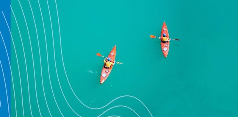 Two kayaks in a blue sea seen from above.