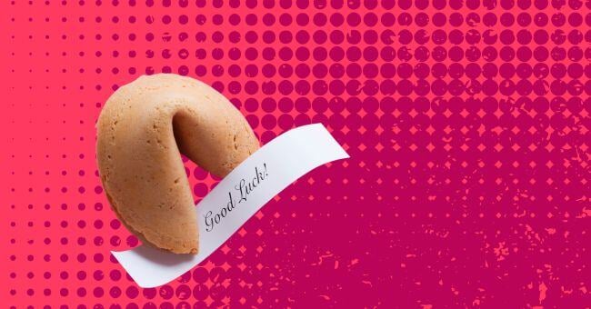 A fortune cookie on a textured pink red background. A slip of paper reads Good Luck!